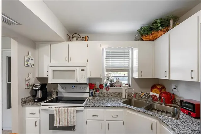 a kitchen with stainless steel appliances kitchen island granite countertop a sink and cabinets