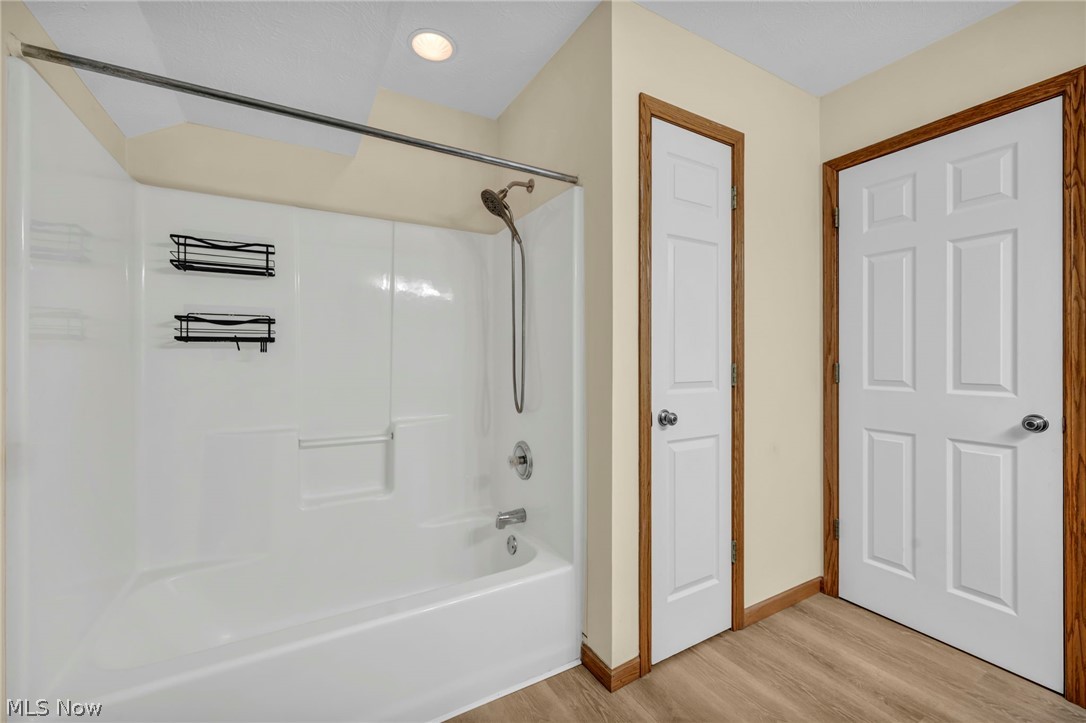 9842 Johnnycake Ridge Road Mentor, OH 44060 - Photo 26 of 40 White tub/shower combination with chrome fixtures, recessed ceiling lighting, and wood-finish flooring