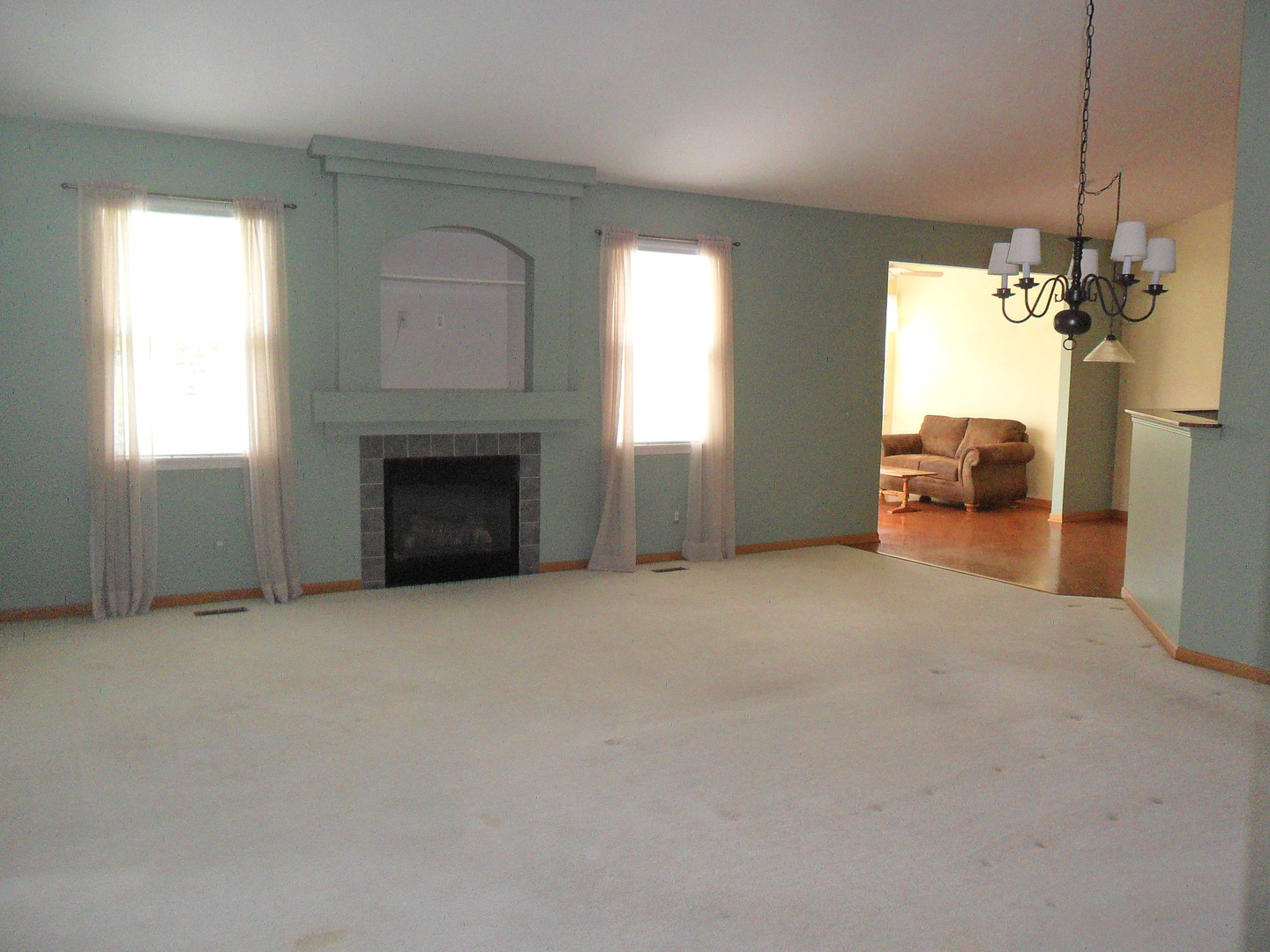 678 Cadillac Circle Romeoville, IL 60446 - Photo 6 of 19 an empty room with windows and fireplace