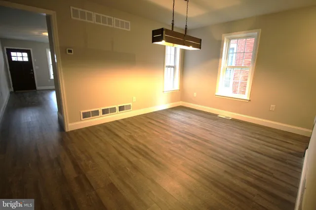 a view of a livingroom with wooden floor and a ceiling fan