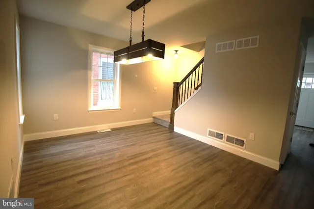 a view of a livingroom with wooden floor and a ceiling fan