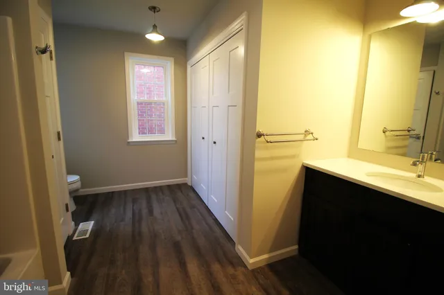 a bathroom with a sink a toilet a shower and a window