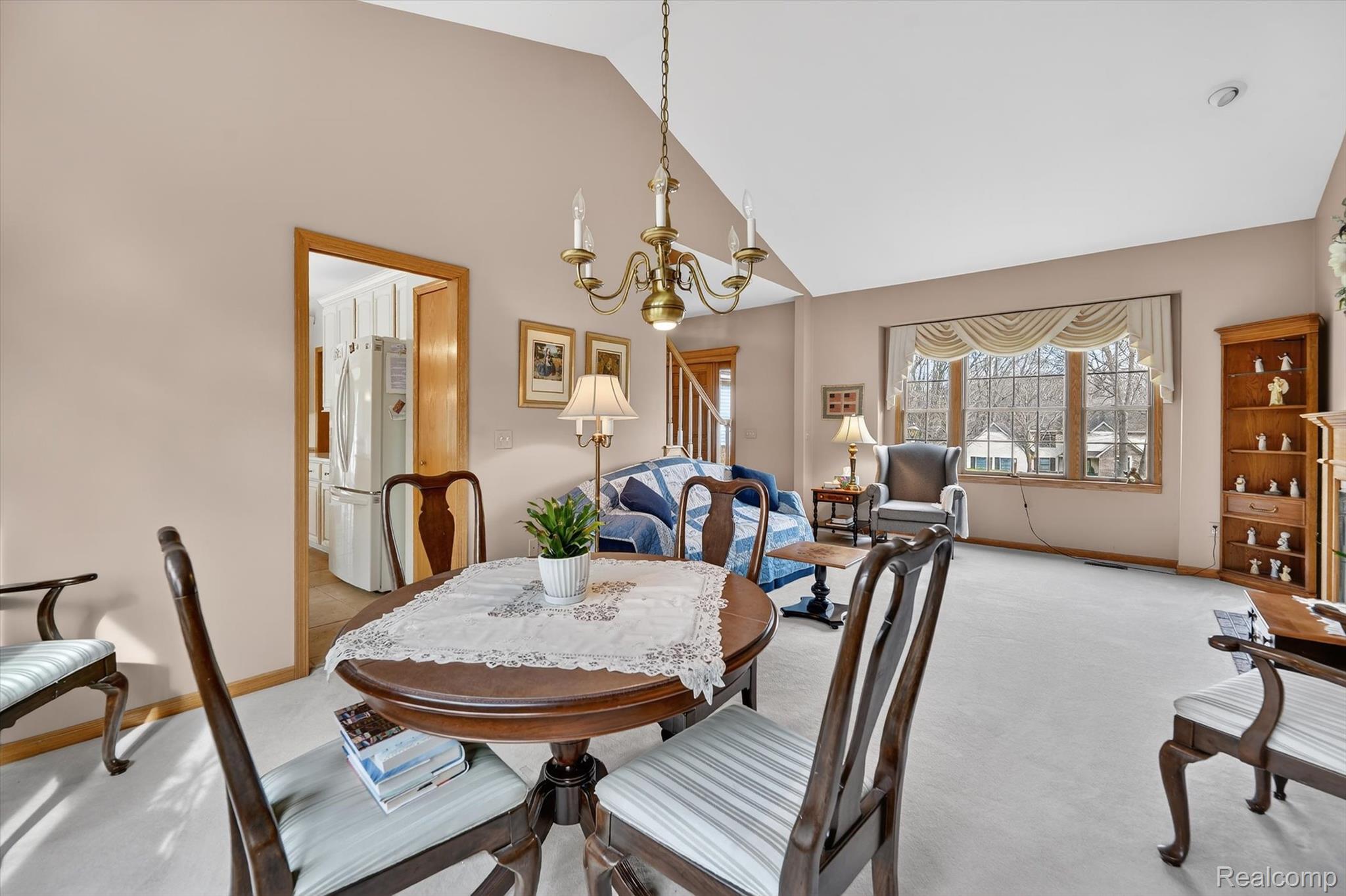 7798 Lee Road Brighton, MI 48116 - Photo 9 of 49 Dining space featuring vaulted ceiling, suspended lighting, and light carpet