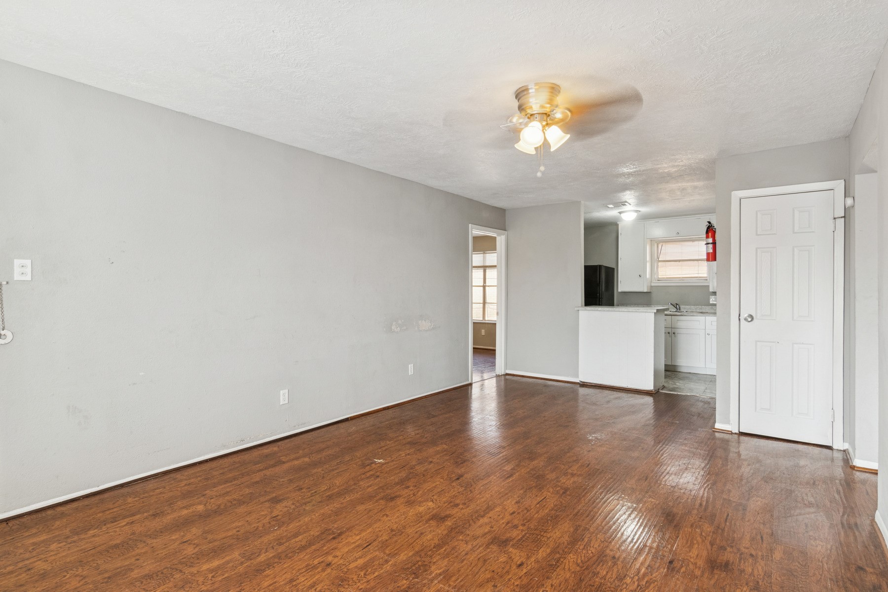 3631 North MacGregor Way, Unit 7 Houston, TX 77004 - Photo 8 of 12 a view of a livingroom with a kitchen counter top a refrigerator and a chandelier