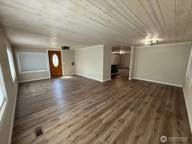 a view of empty room with wooden floor