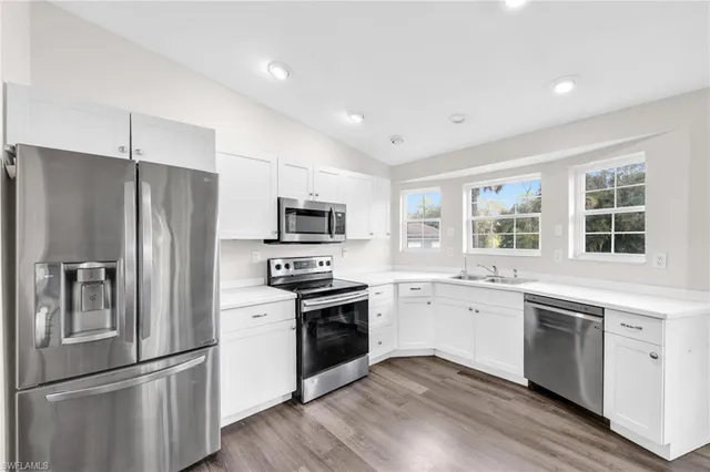 a kitchen with stainless steel appliances a refrigerator sink and microwave
