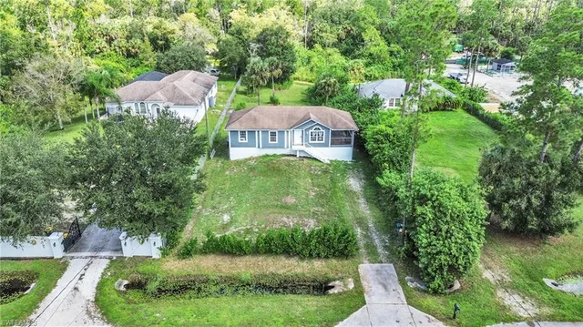 a aerial view of a house with a yard and large trees