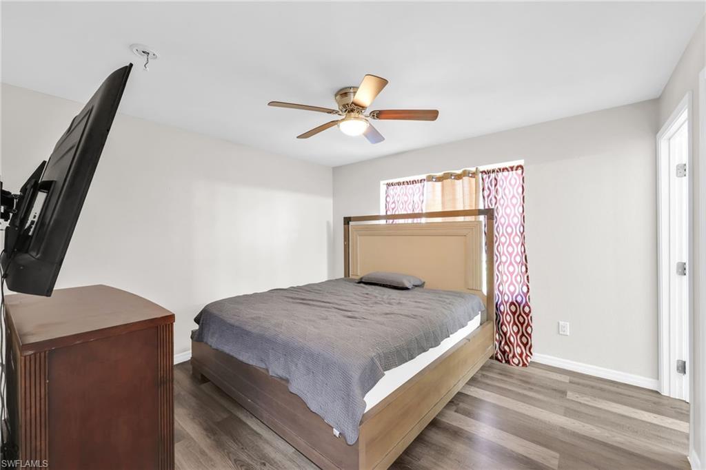 4015 16th Avenue Southeast Naples, FL 34117 - Photo 5 of 22 a bedroom with a bed and a chandelier