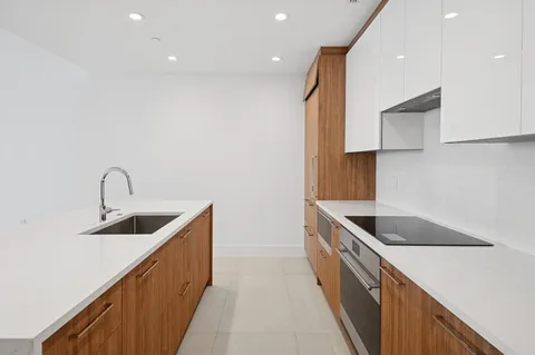 a kitchen with kitchen island granite countertop a sink and a stove