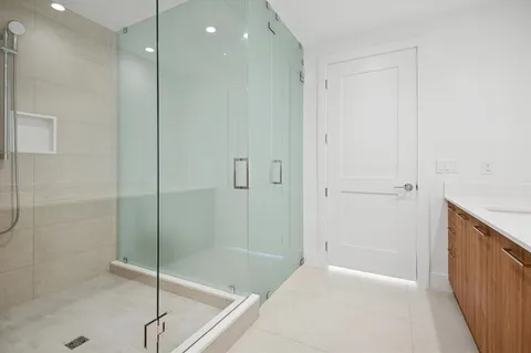 a bathroom with a shower and a glass door