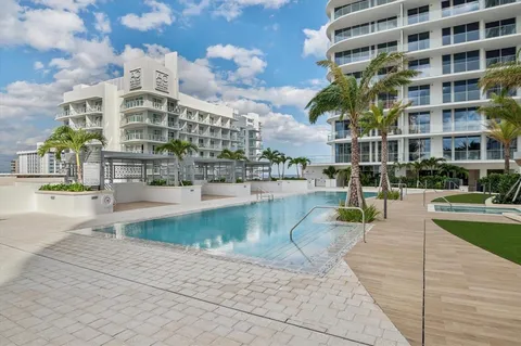 a view of a swimming pool with a bench in front of building