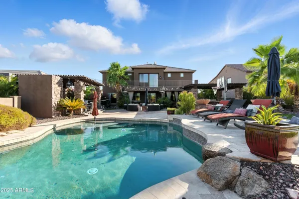 a view of a house with swimming pool and sitting area