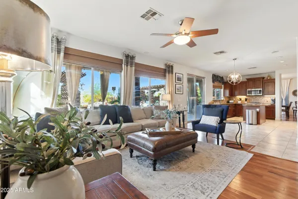 a living room with furniture kitchen view and a large window