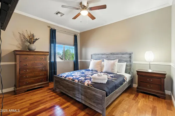 a living room with hard wood floors and a ceiling fan