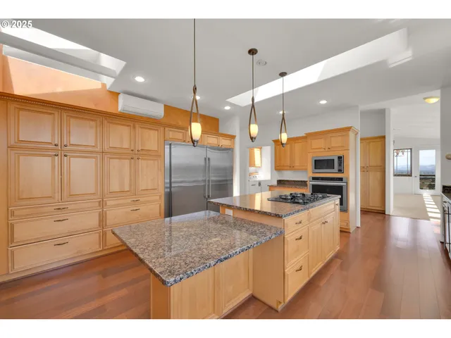 a kitchen with granite countertop a stove a sink and a refrigerator