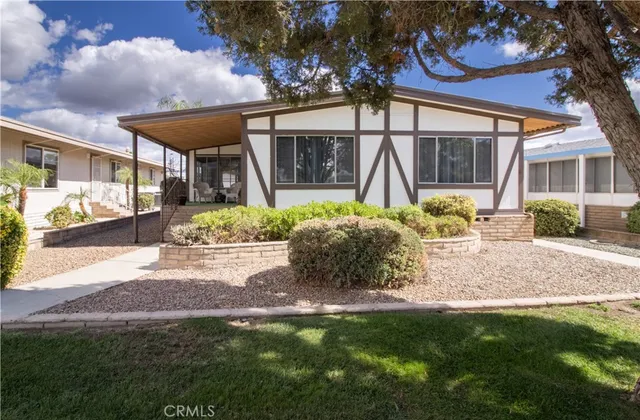 a front view of a house with a yard and potted plants