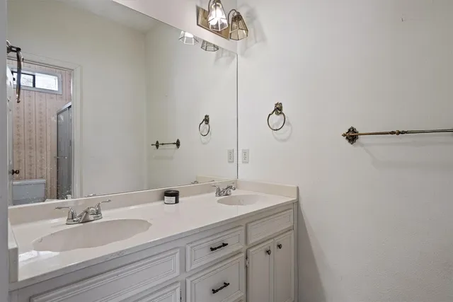 a bathroom with a granite countertop sink a mirror and vanity