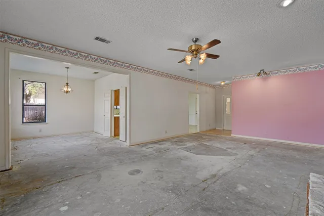 a view of a big room with chandelier fan and windows