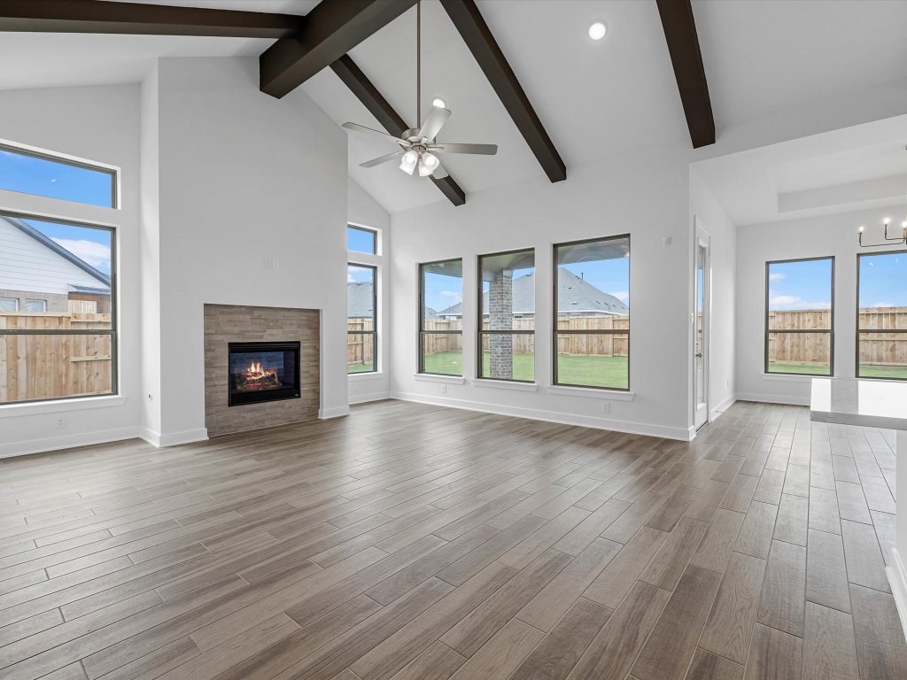 132 Meadow Beauty Lane Georgetown, TX 78633 - Photo 4 of 19 an empty room with wooden floor fireplace and windows