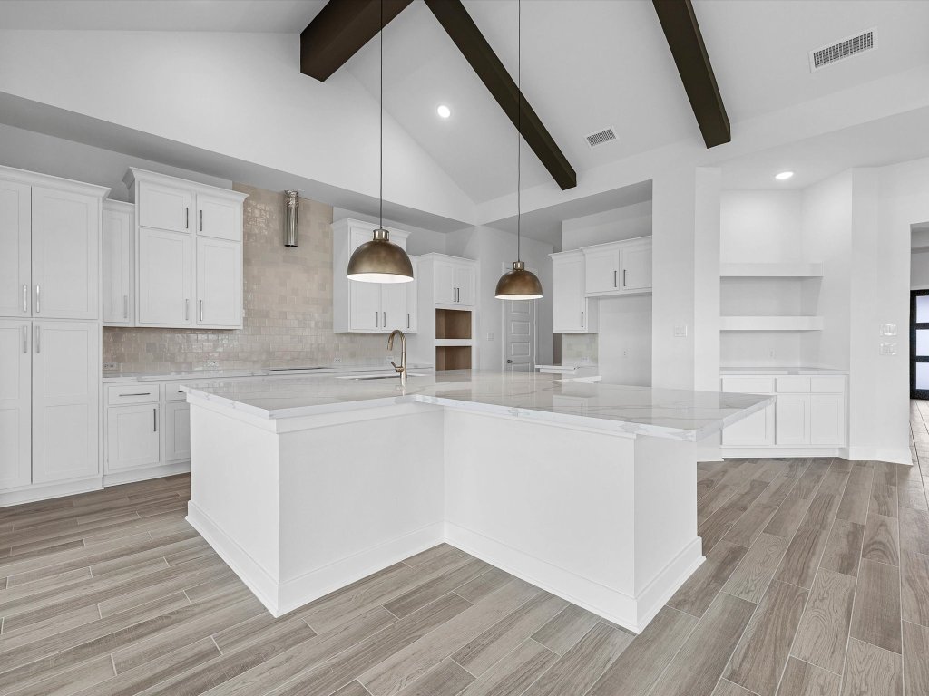 132 Meadow Beauty Lane Georgetown, TX 78633 - Photo 6 of 19 a white kitchen with wooden floor and stainless steel appliances