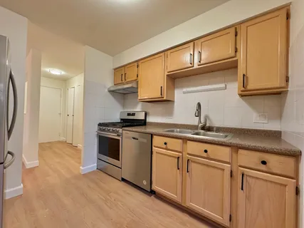 a kitchen with granite countertop a sink stainless steel appliances and cabinets