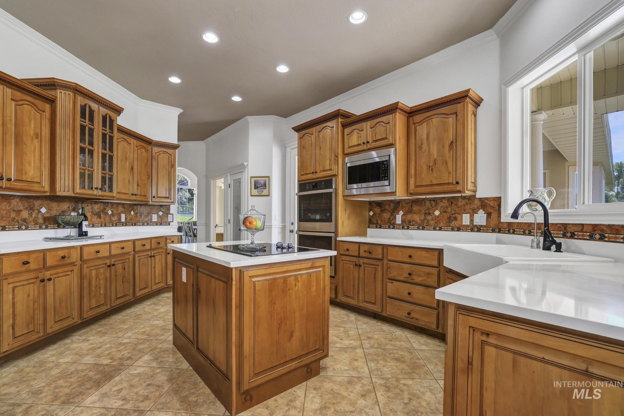 1301 Kanaka Rapids Road Buhl, ID 83316 - Photo 28 of 50 Expansive kitchen featuring wood-finish cabinetry, white countertops, and a tiled backsplash