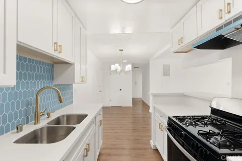 a kitchen with sink a stove and cabinets