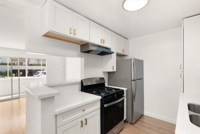 a kitchen with stainless steel appliances a white stove top oven and a refrigerator