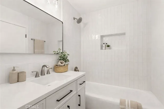 a bathroom with a granite countertop sink a toilet and bathtub