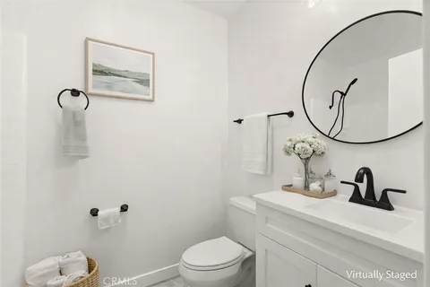 a bathroom with a toilet sink vanity and mirror