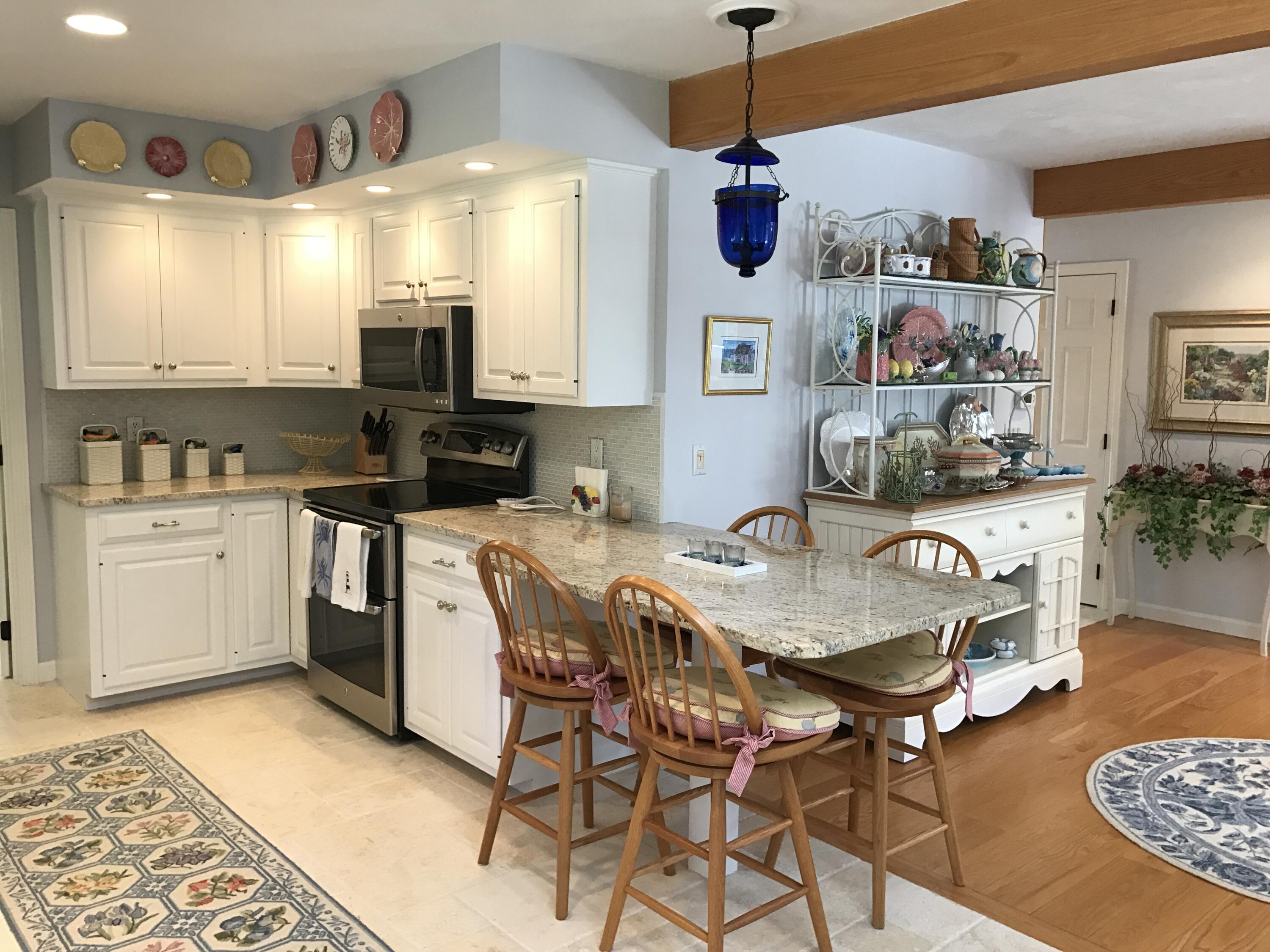 182 Sesuit Neck Road East Dennis, MA 02641 - Photo 11 of 35 a kitchen with stainless steel appliances kitchen island granite countertop a sink a stove a table and chairs