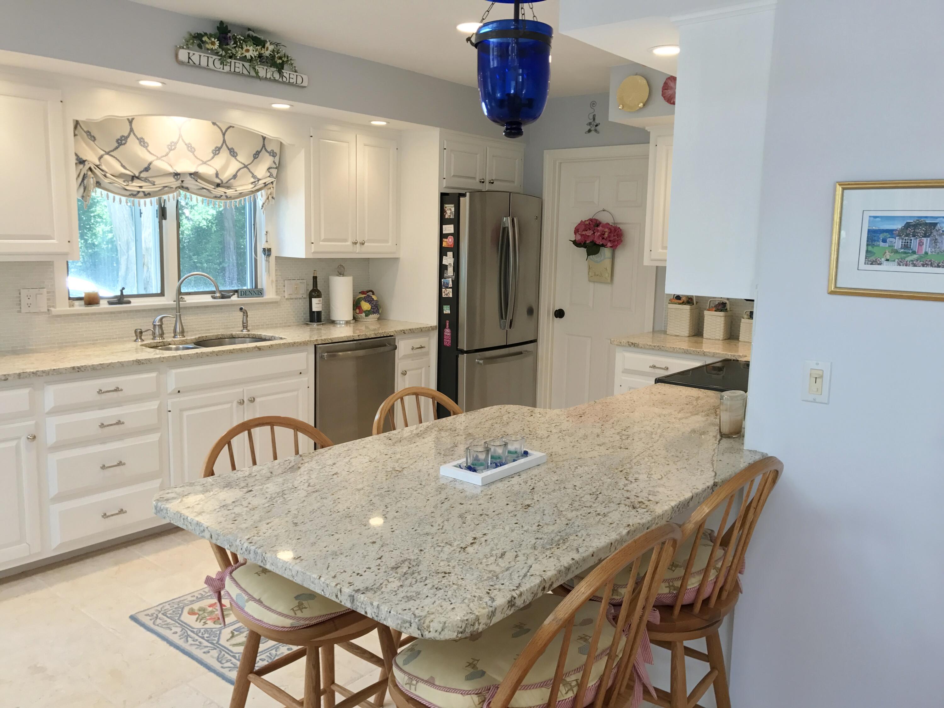 182 Sesuit Neck Road East Dennis, MA 02641 - Photo 12 of 35 a kitchen with granite countertop a table and chairs in it