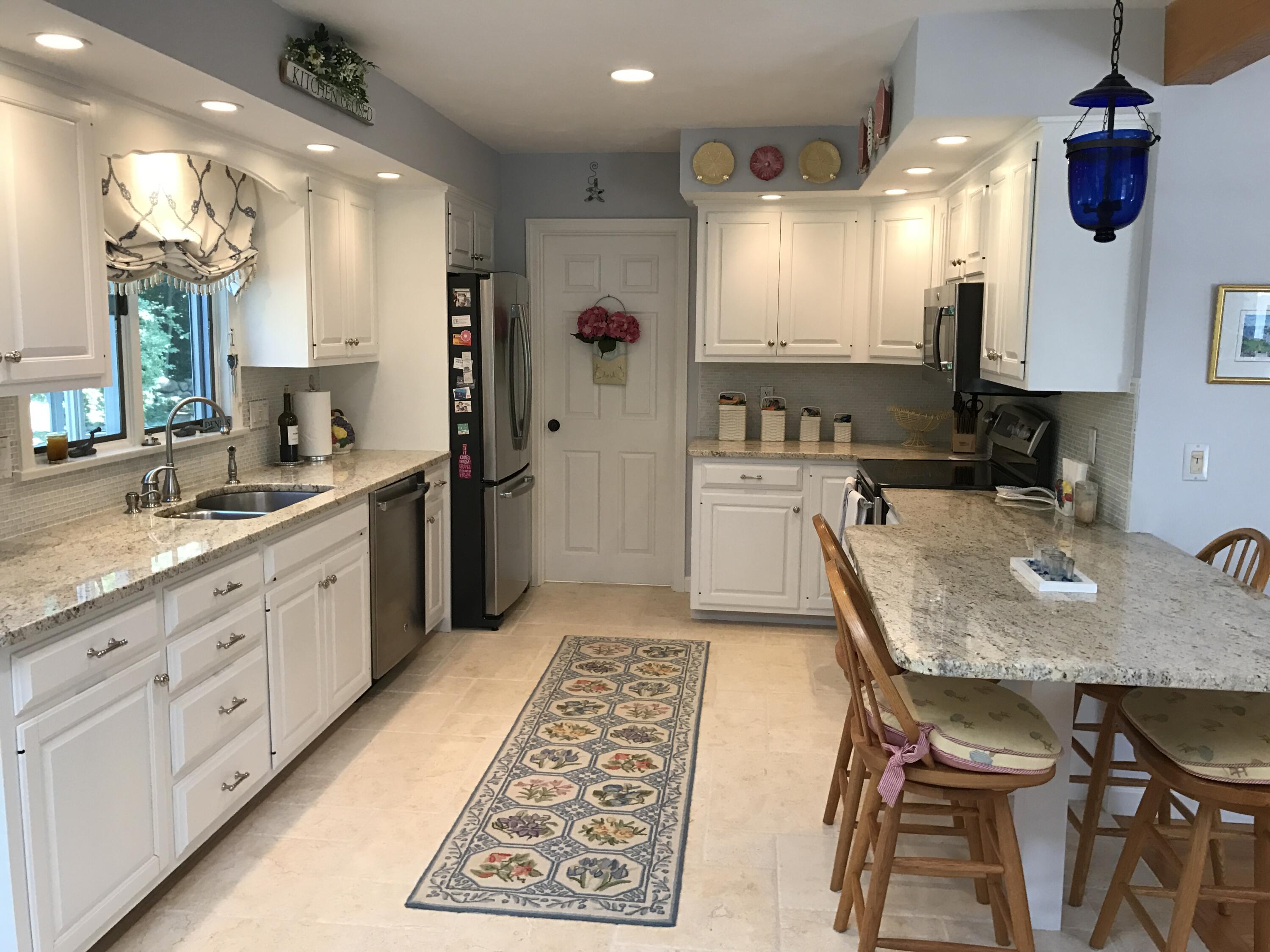 182 Sesuit Neck Road East Dennis, MA 02641 - Photo 13 of 35 a kitchen with a table chairs sink and cabinets