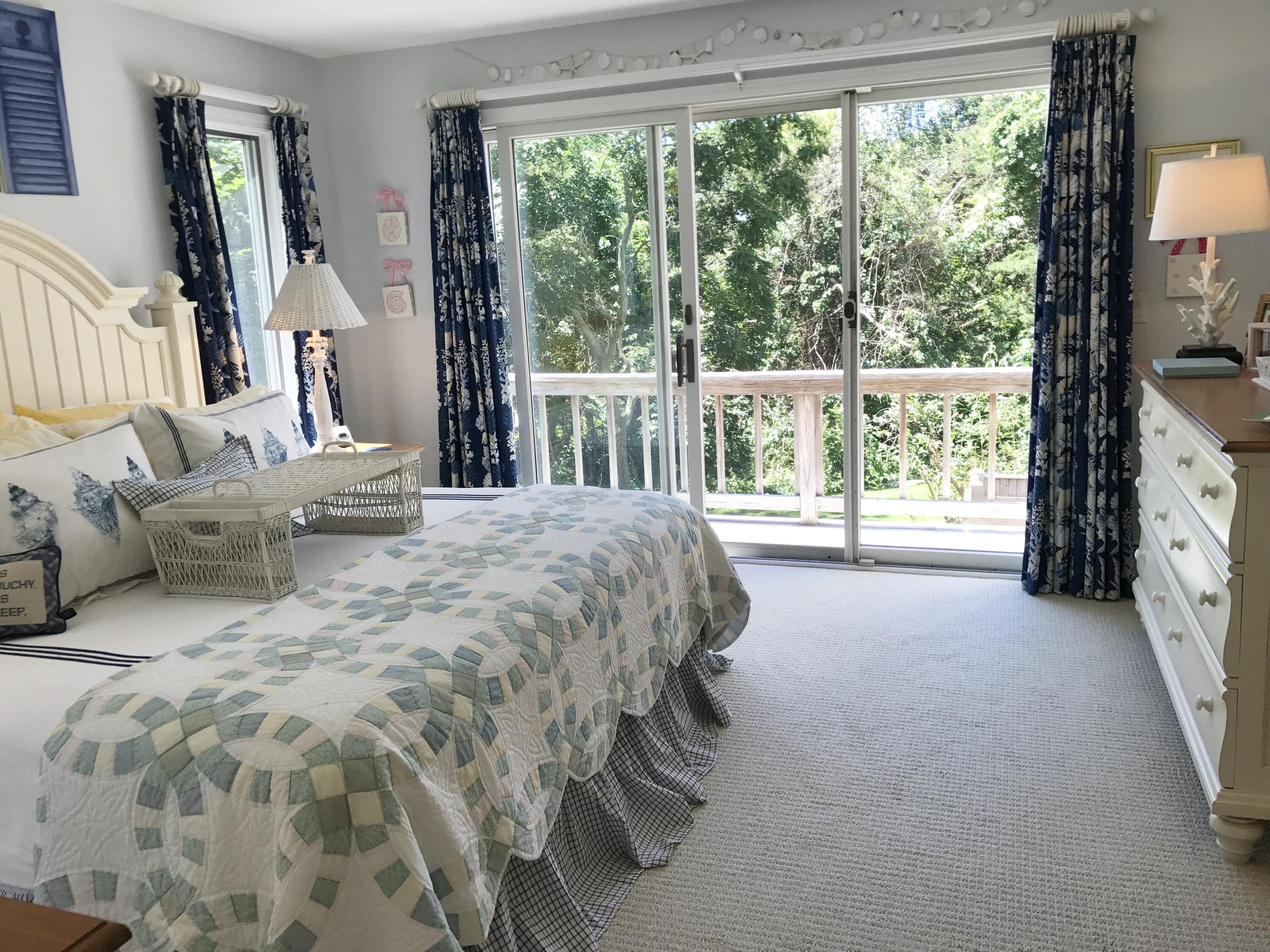 182 Sesuit Neck Road East Dennis, MA 02641 - Photo 18 of 35 a spacious bedroom with a bed and large windows