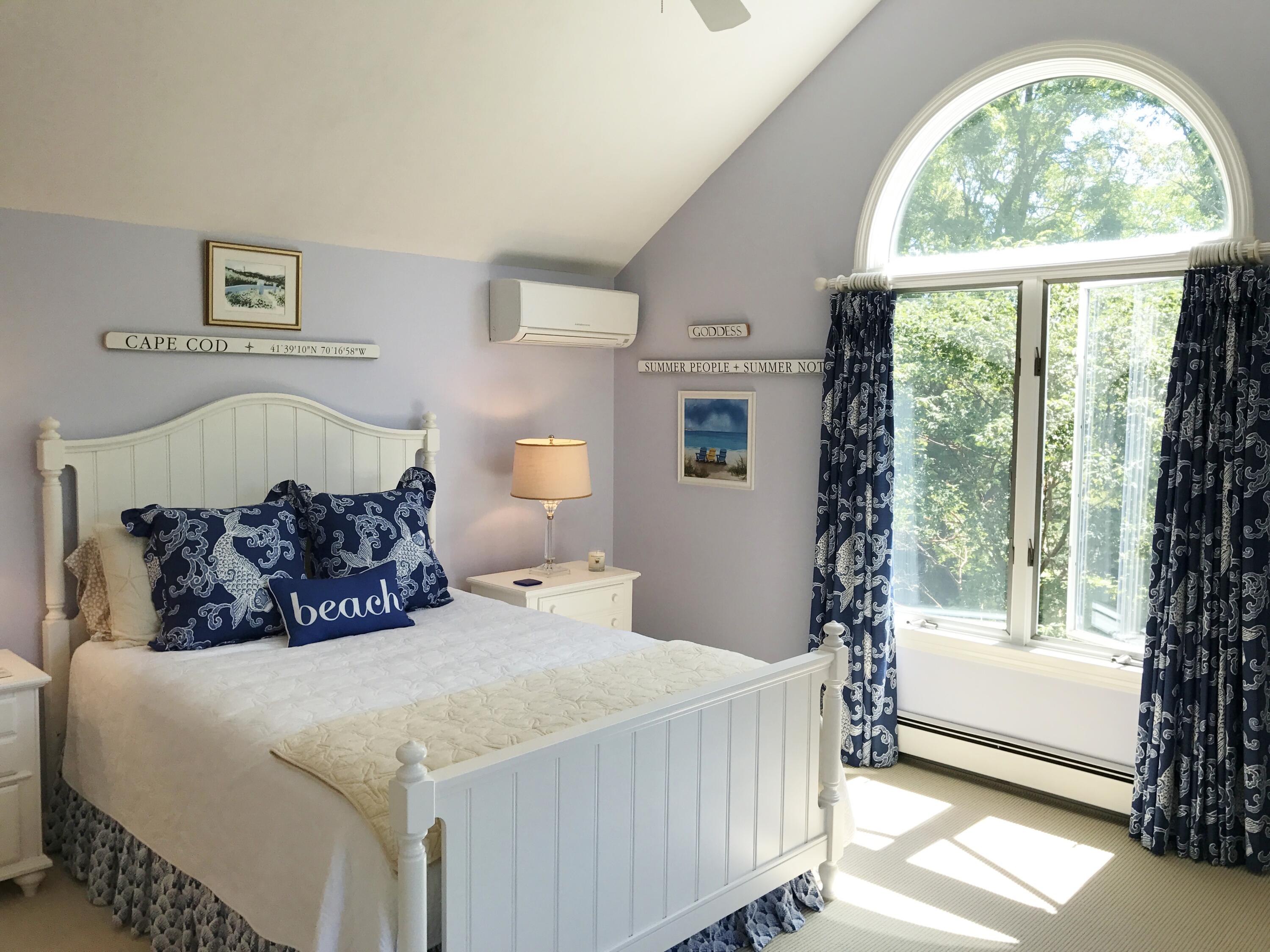 182 Sesuit Neck Road East Dennis, MA 02641 - Photo 26 of 35 a bedroom with a bed and a large window