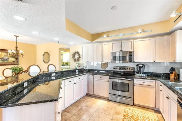 a kitchen with granite countertop a white cabinets and wooden floor