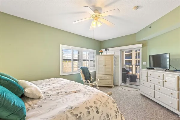 a bedroom with a bed a chair and a chandelier