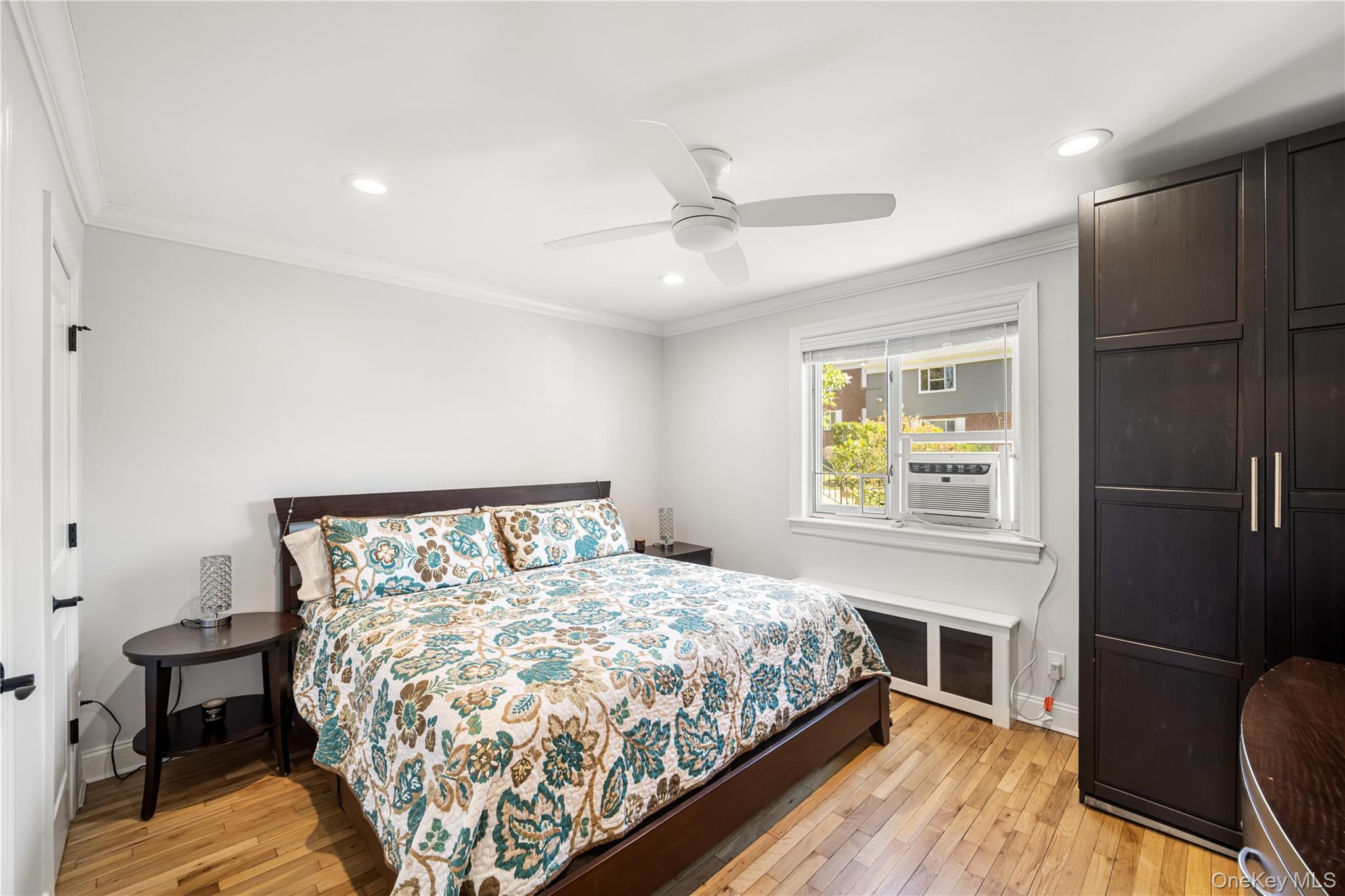 224-09 Manor Road, Unit LOWER) 2408 Queens, NY 11427 - Photo 12 of 20 a bed sitting in a bedroom next to a window and a chandelier