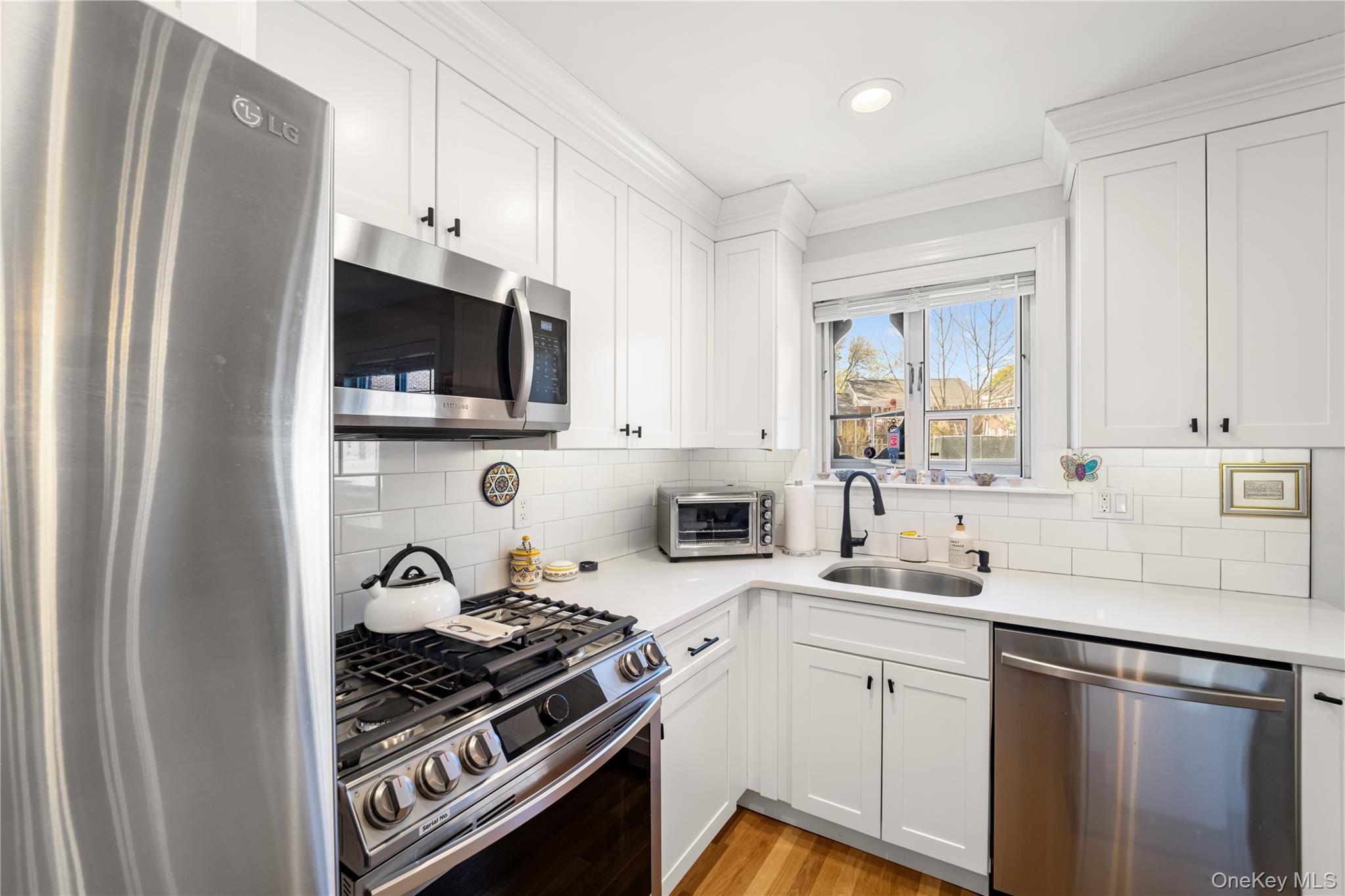 224-09 Manor Road, Unit LOWER) 2408 Queens, NY 11427 - Photo 9 of 20 a kitchen with cabinets stainless steel appliances and a counter space
