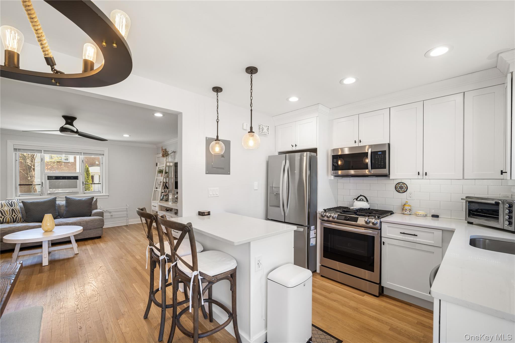 224-09 Manor Road, Unit LOWER) 2408 Queens, NY 11427 - Photo 10 of 20 a kitchen with stainless steel appliances a stove a sink dishwasher a refrigerator with a dining table and chairs with wooden floor
