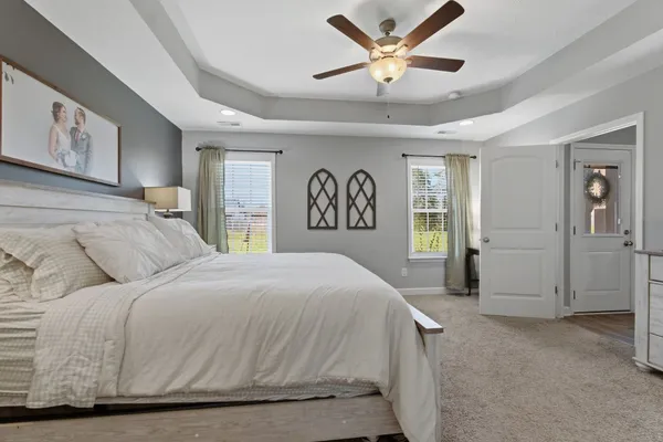 a spacious bedroom with a large bed and a chandelier