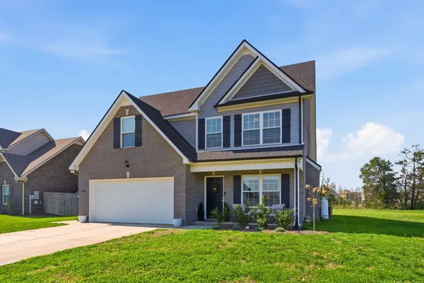 a front view of a house with a yard and garage