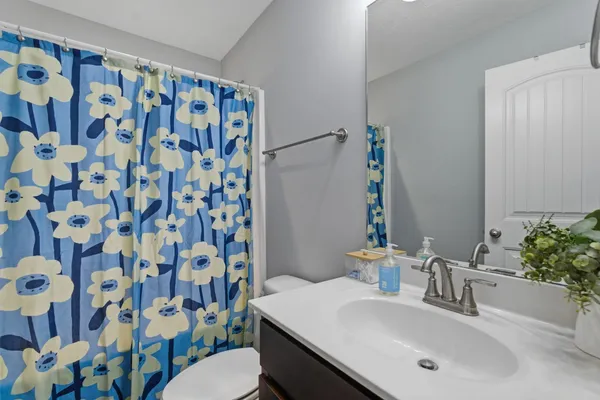a bathroom with a sink and mirror with toilet