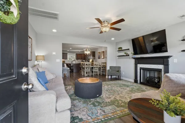 a living room with furniture a fireplace and a flat screen tv