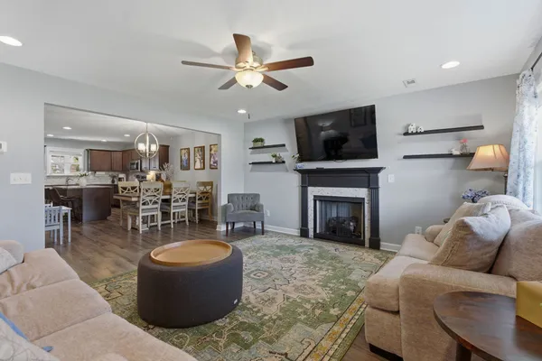 a living room with furniture a flat screen tv and a fireplace