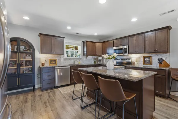 a kitchen with a table chairs refrigerator and cabinets