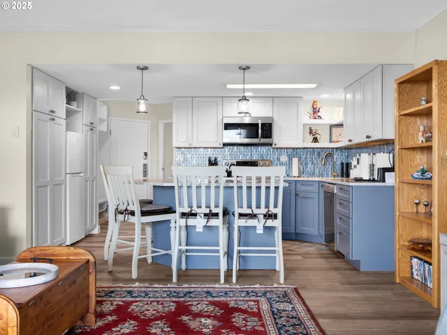 a open kitchen with stainless steel appliances kitchen island granite countertop a sink and a refrigerator