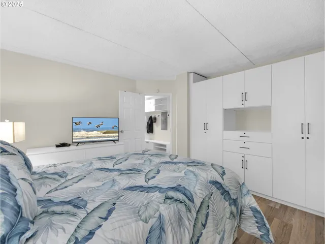 a bedroom with a bed and a refrigerator