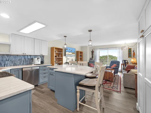 a kitchen with stainless steel appliances granite countertop a table and chairs in it