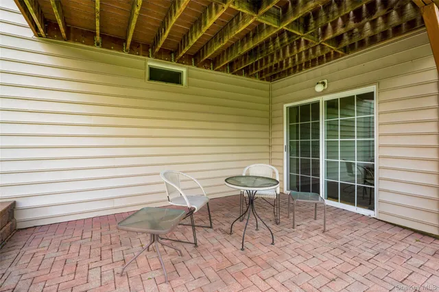 a roof deck with table and chairs and potted plants